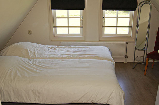 Vakantiewoning Limosa Wieringen - de primaire slaapkamer Vakantiewoning Limosa Wieringen - slaapkamer 1 met twee losse boxsprings